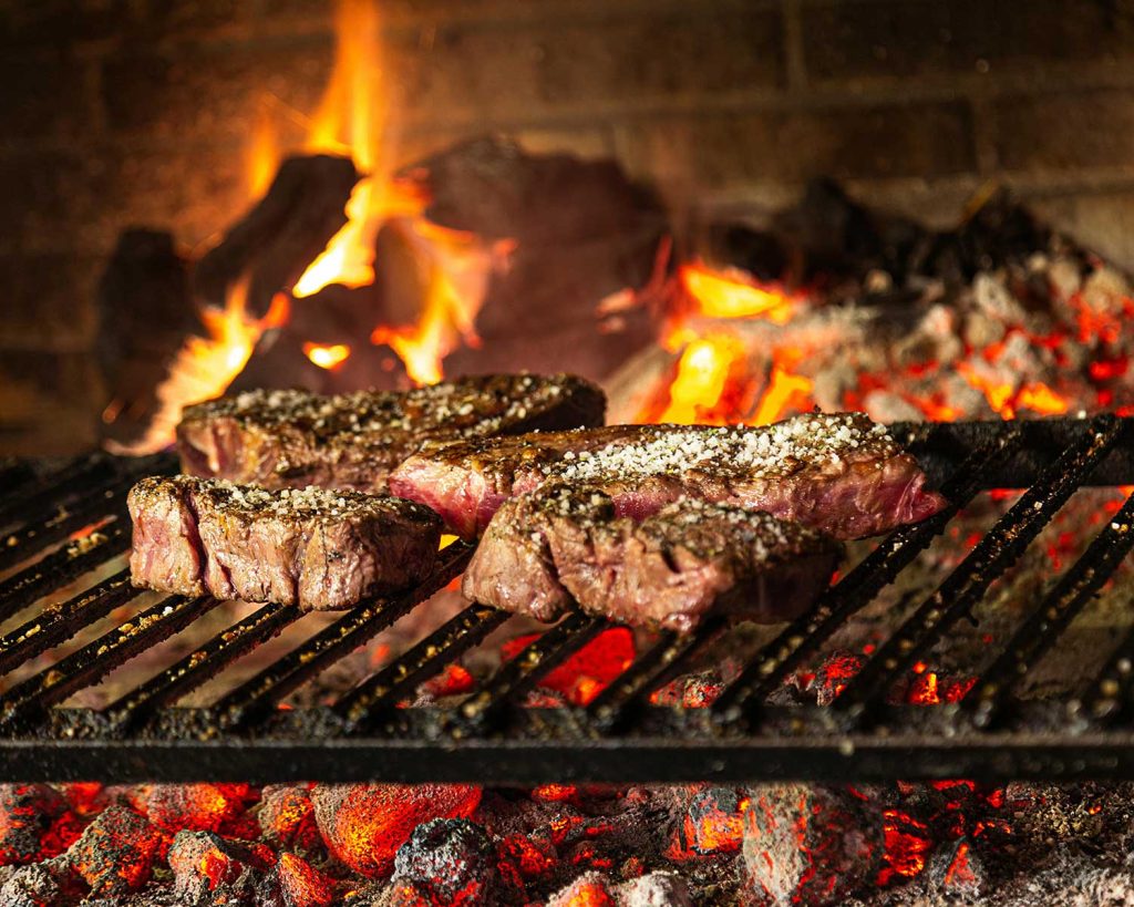 Grilling meat on an Argentinian open flame grill.
