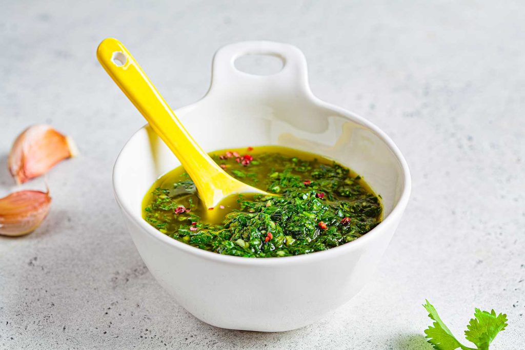 A small bowl of Chimichurri sauce.