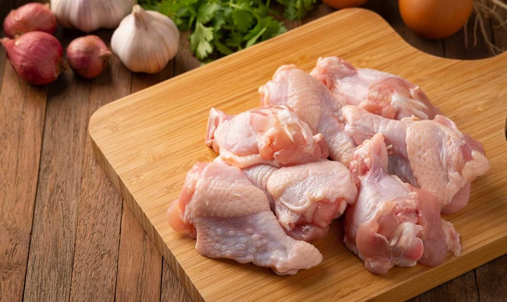Cutting board with raw chicken wings cut and separated